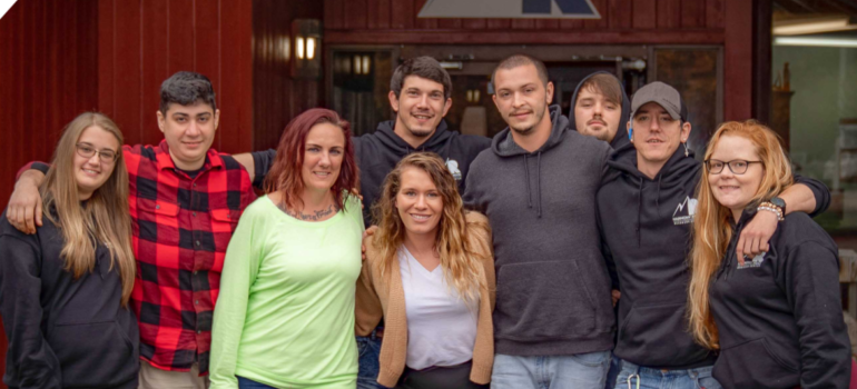 A group of people standing in front of a facility for a rehab for professionals.