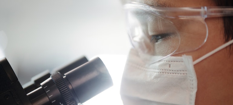 a man looking at a microscope 