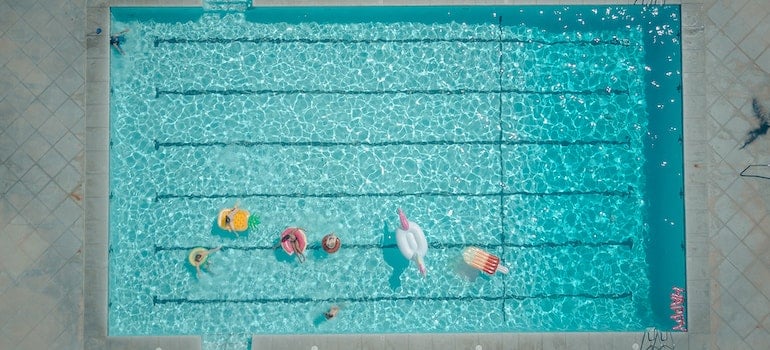 A top view of a swimming pool in which people are hanging out.