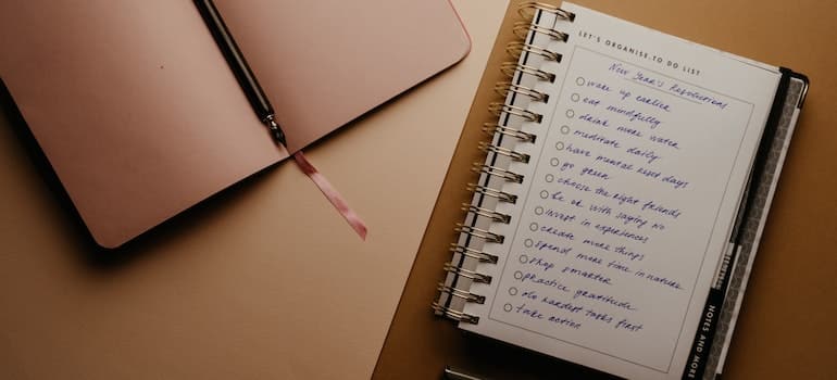 A close-up of a notebook on a desk, showing a to-do list.