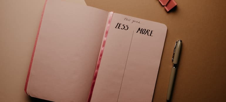 A notebook on a table, with a page split into “less” and “more” columns.