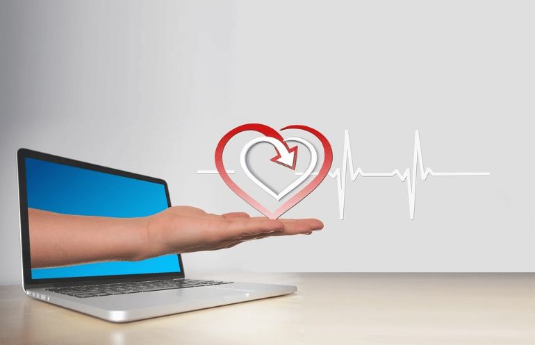 An illustration of a hand emerging from a laptop holding a heart symbol.