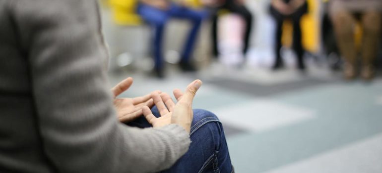 A close-up of a person talking during a group therapy session.