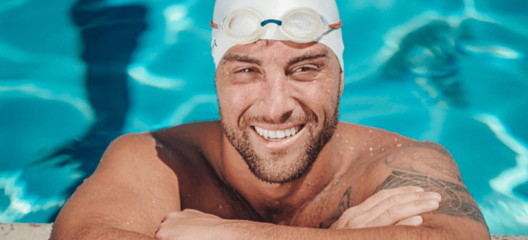 A smiling man in a swimming pool.