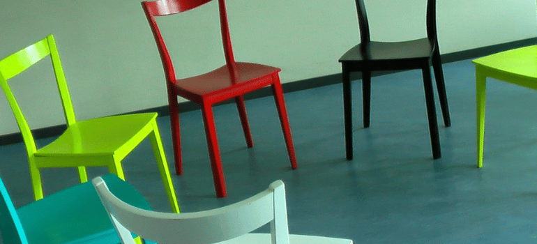 Colorful chairs placed in a circle indoors.