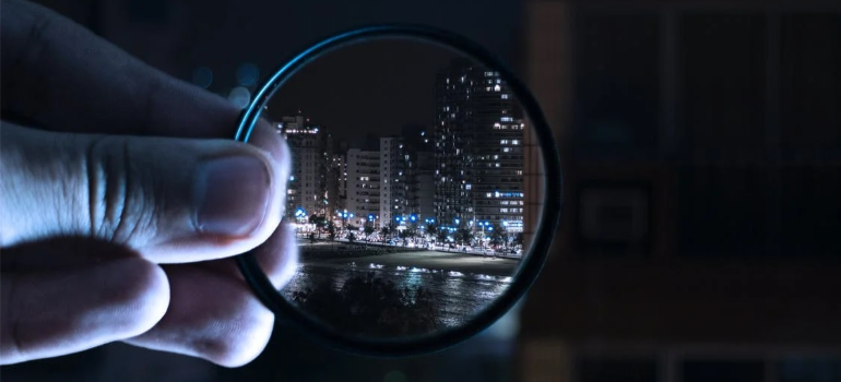 A magnifying glass held over a cityscape.