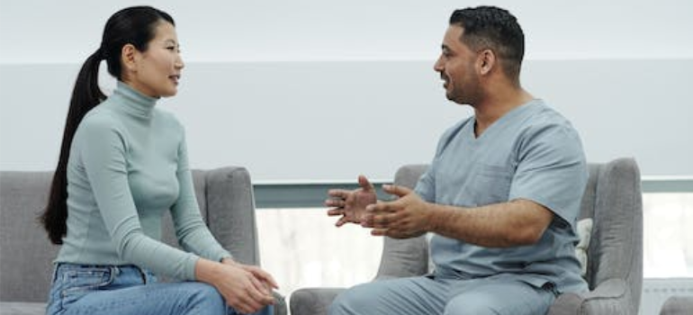 A doctor and a patient having a discussion while seated indoors.