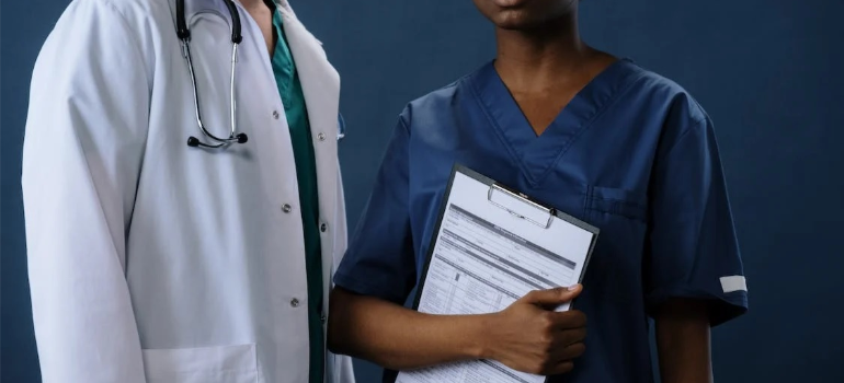 A crop of doctors over a blue background, as one holds medical records.