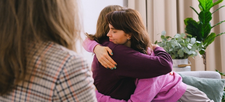 sisters giving each other a hug at a family therapy