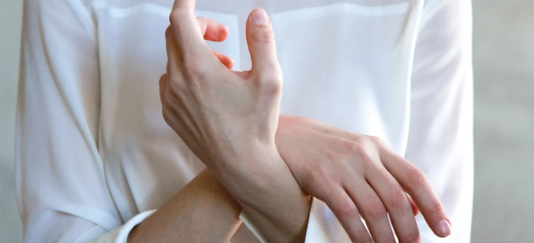 A close-up of the hands of a woman in a white long-sleeved top showing how to prepare for a cocaine detox program in West Virginia.
