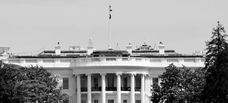 A black-and-white photo of the White House in Washington DC.