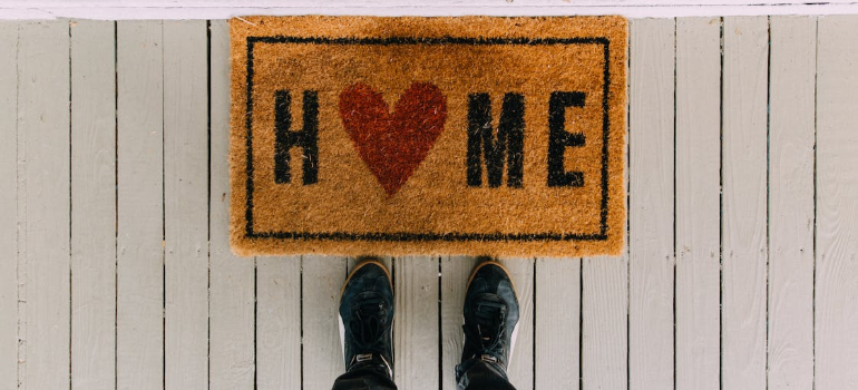 A close-up of a door mat that reads “home”.