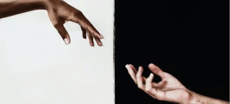 An illustration of a black and a white hand stretching out to each other when you need help to prepare for a cocaine detox program in West Virginia.
