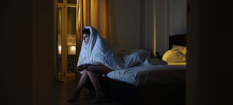 Woman watching TV from her bed.