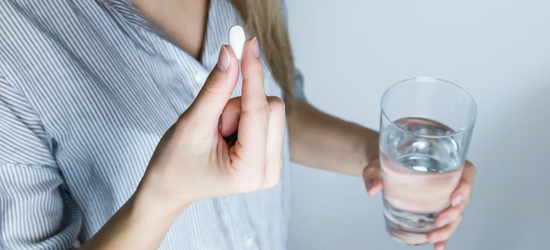 person taking fentanyl with a glass of water