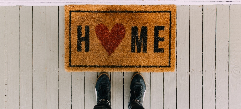 a doormat with the word home on it and a heart instead of the O