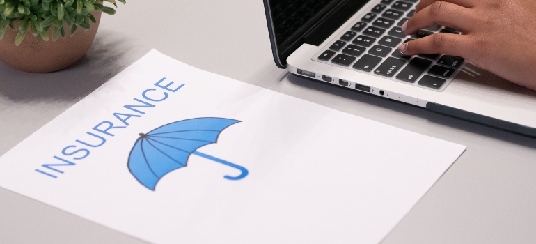 the word insurance printed in blue on a piece of paper and a picture of a blue umbrella under it