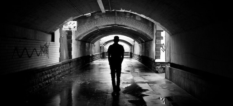 a man walking alone through a tunnel