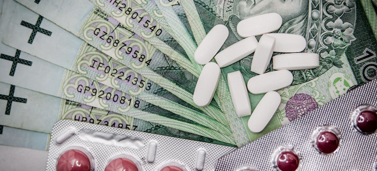 Pills on a stack of money representing the connection between self-harm and addiction