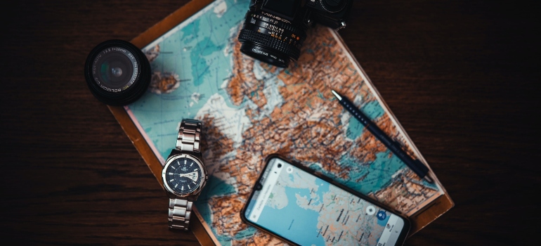 travel gear including a map, phone, watch, camera and a lense 