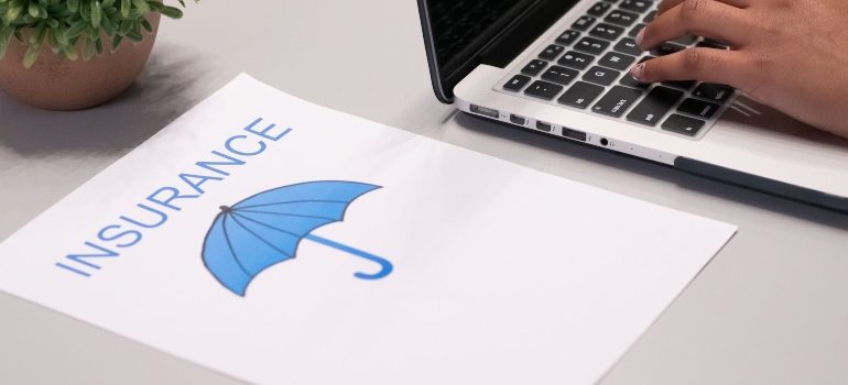 the word insurance and a blue umbrella on white paper
