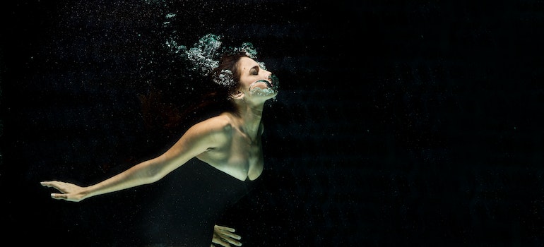 Woman diving in dark water