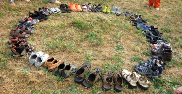 A circle of shoes on grass, symbolizing support groups in addiction treatment.