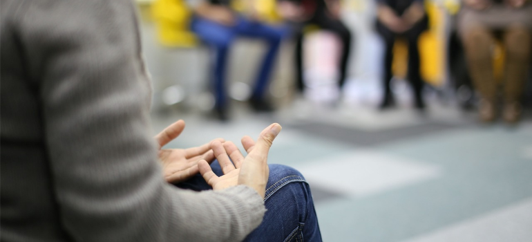A close-up of a person sharing with a group during a group therapy session.