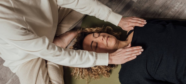 A close-up of two people during a Reiki session.