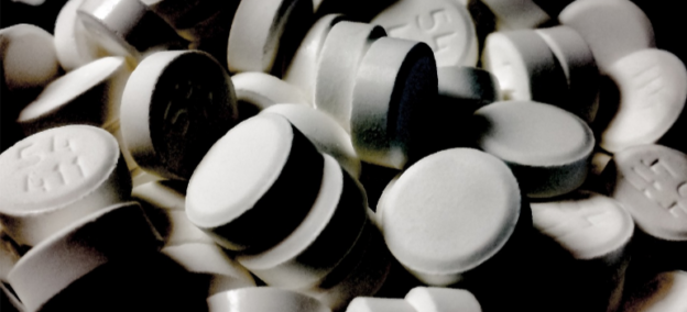 A close-up of white pills, symbolizing the role of pharmaceutical companies in the opioid epidemic.