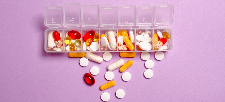 An assortment of pills in a plastic container.