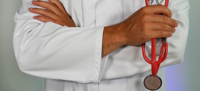 A close-up of a doctor wearing a stethoscope, illustrating how the involvement of pharmaceutical companies in the opioid epidemic included influence on medical professionals.