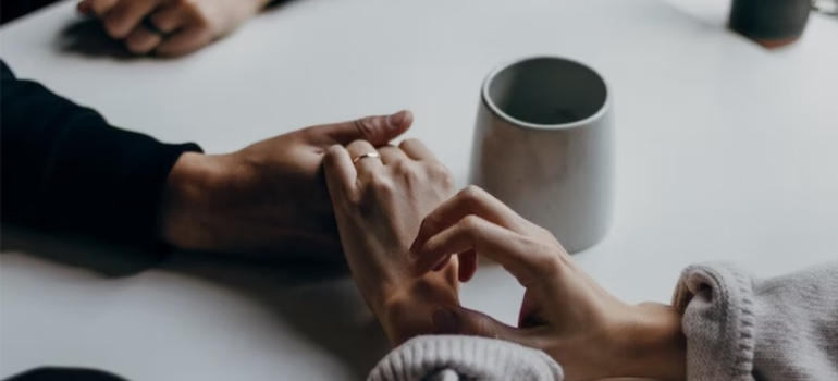 A close-up of two people holding hands, illustrating the value in family support in addiction recovery.
