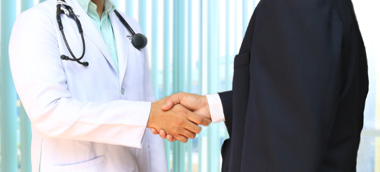 A doctor and a patient shaking hands.