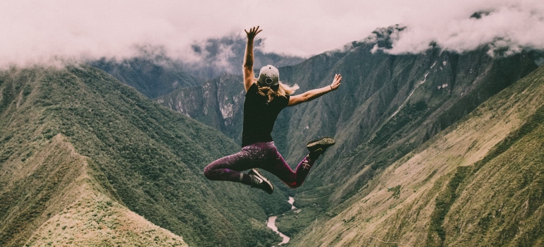 Person jumping in front of a scenic mountain view