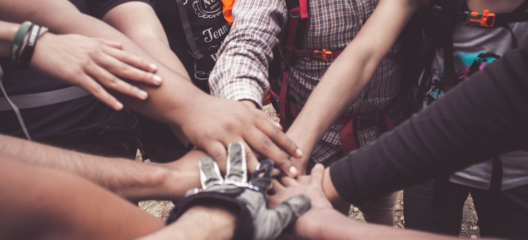 A close-up of a group of people joining hands.