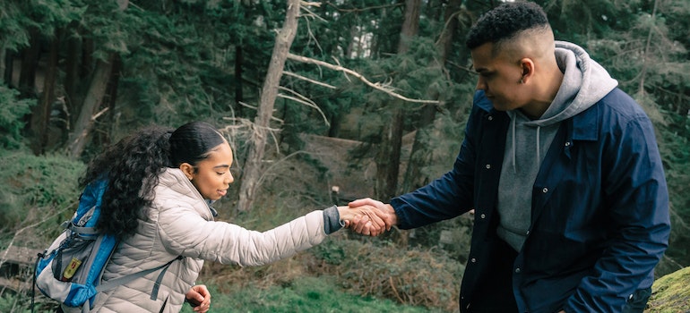 A man helping a woman in the forest representing support through the Ambien addiction withdrawal process