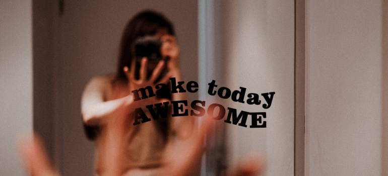 Person high-fiving themselves in the mirror with an affirmation "make today awesome" written on it