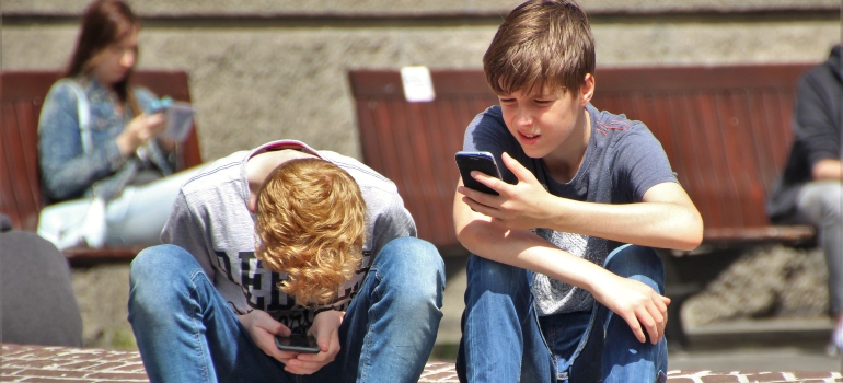 two boys looking at their phones