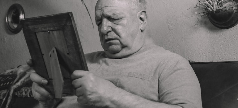 an older man looking at the picture depressed and sad