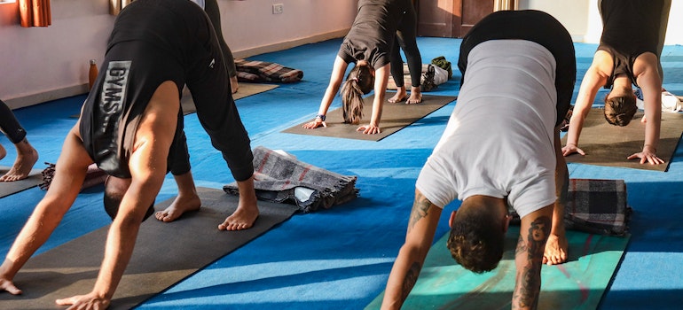 A diverse group of individuals in yoga poses showcasing the power of communal exercise for recovery and sobriety