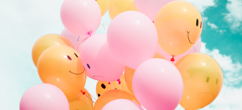 A group of orange and pink balloons floating.