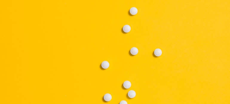 pills on yellow background representing the Impact of Ambien Addiction work or school performance