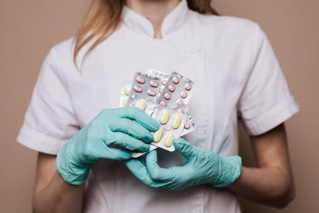 A doctor holding different medication in their hands