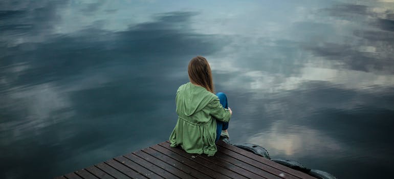 A person sitting alone by the lake
