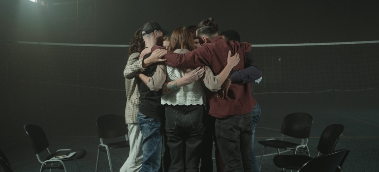 A group of people hugging during group therapy near New Lexington