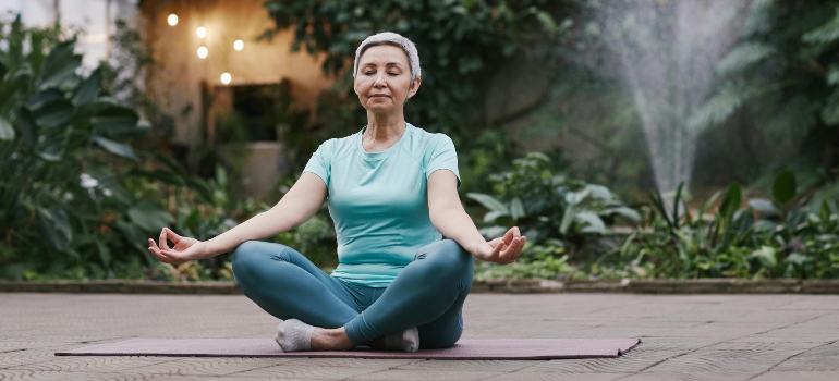 An elderly woman sitting in a yoga pose
