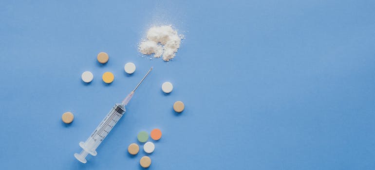 A syringe and pills on a blue background