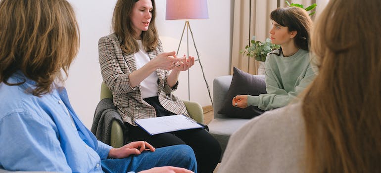 A therapist talking to people during a group therapy regarding adjustment disorder and substance abuse
