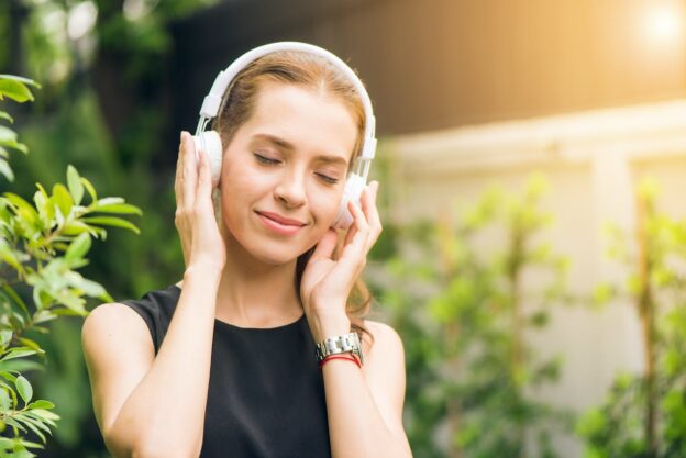 A young woman listening to the music with headphones on her head